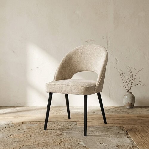 Elegante beige fauteuil met ronde rugleuning en zwarte houten poten, perfect voor moderne woon- of kantoorruimtes.
