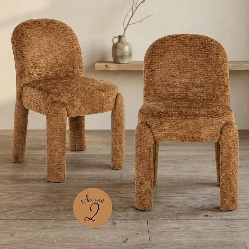 Twee vintage houten eetkamerstoelen met zachte, gebreide stoffen bekleding in een minimalistische interieursetting, perfect voor een gezellige eetruimte.