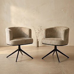Twee moderne fauteuils met zachte bekleding en zwarte poten, geplaatst in een minimalistische interieursetting met een vaas met takken op de achtergrond.