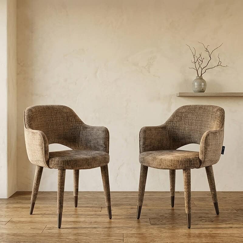 Zwei Vintage-Holzsessel mit weicher Polsterung in einem modernen, minimalistischen Interieur mit hellen Wänden und Holzboden – perfekt für eine gemütliche Sitzecke.