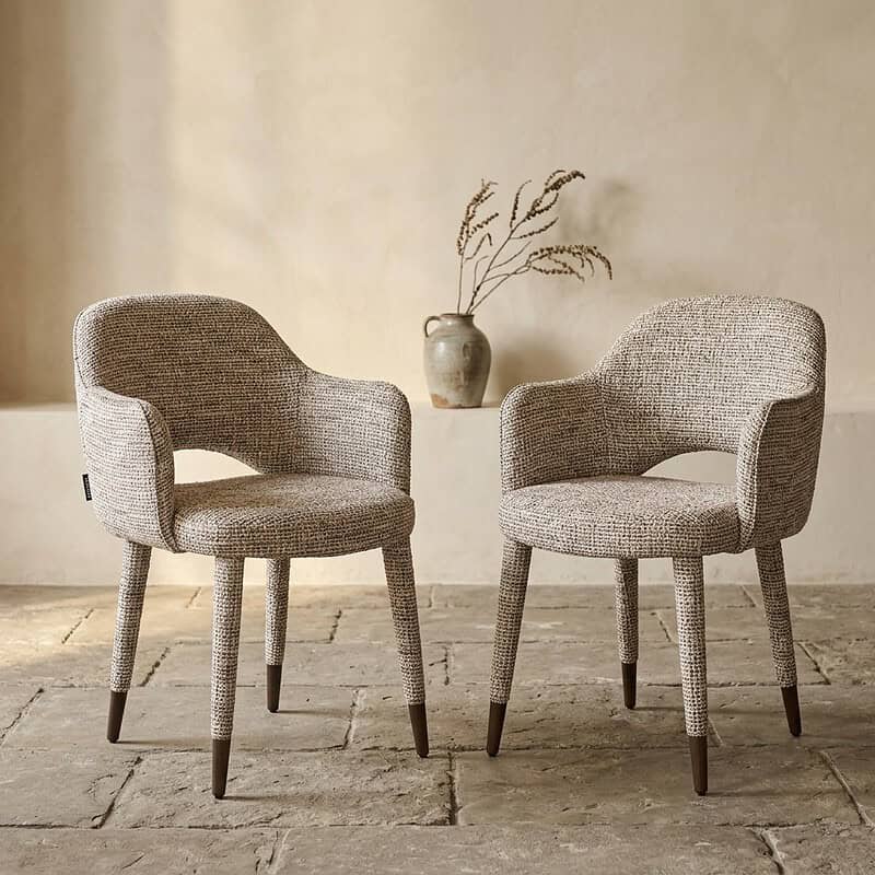 Zwei stilvolle Holzsessel mit weicher Stoffpolsterung, perfekt für ein modernes Wohnzimmer oder einen Büroraum. Bequeme Sitzgelegenheiten mit zeitlosem Design und natürlicher Optik.