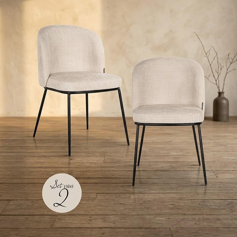Zwei moderne Esszimmerstühle mit hellem Bezug und schwarzen Metallbeinen – perfekt für ein stilvolles Esszimmer oder Wohnzimmer.