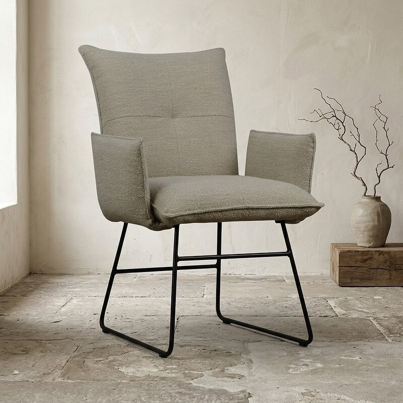 Moderne houten fauteuil met stoffen bekleding en zwart metalen frame, perfect voor een stijlvolle en comfortabele zithoek in huis of kantoor.