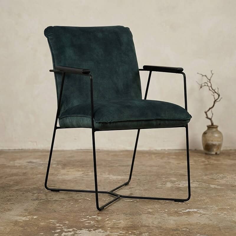 Moderne fauteuil met houten armleuningen en metalen frame, bekleed met zachte groene stof, perfect voor een stijlvolle woonkamer of kantoorruimte.