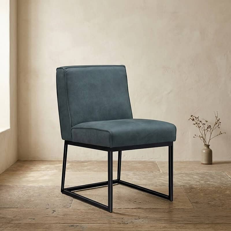 Moderne blauwe eetkamerstoel met zwart metalen frame, perfect voor een stijlvolle eetkamer of woonkamer. Comfortabel en duurzaam design, ideaal voor elk interieur.