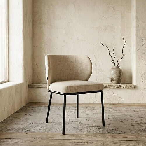 Moderne eetkamerstoel met beige stoffering en zwarte metalen poten, geplaatst in een minimalistische interieursetting met een vintage vaas en takken op de achtergrond.