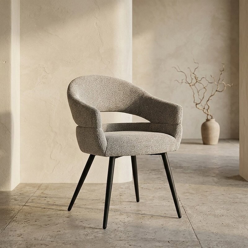 Ein eleganter, moderner Sessel mit weicher Polsterung und schlanken schwarzen Beinen – perfekt für ein stilvolles Wohnzimmer oder Büro.