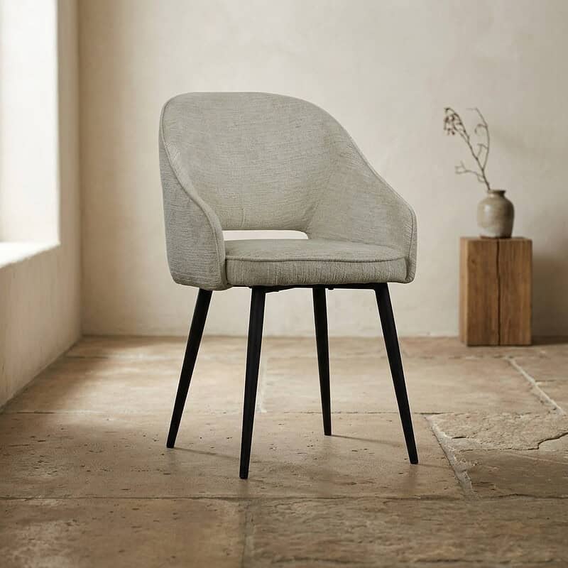 Moderne houten eetkamerstoel met zachte stoffen bekleding en slanke zwarte poten, ideaal voor een stijlvolle en comfortabele eetruimte.