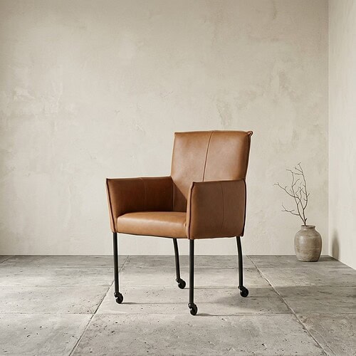 Luxe Mokana lounge stoel in bruin leer met zwarte metalen poten, perfect voor moderne interieurs.
