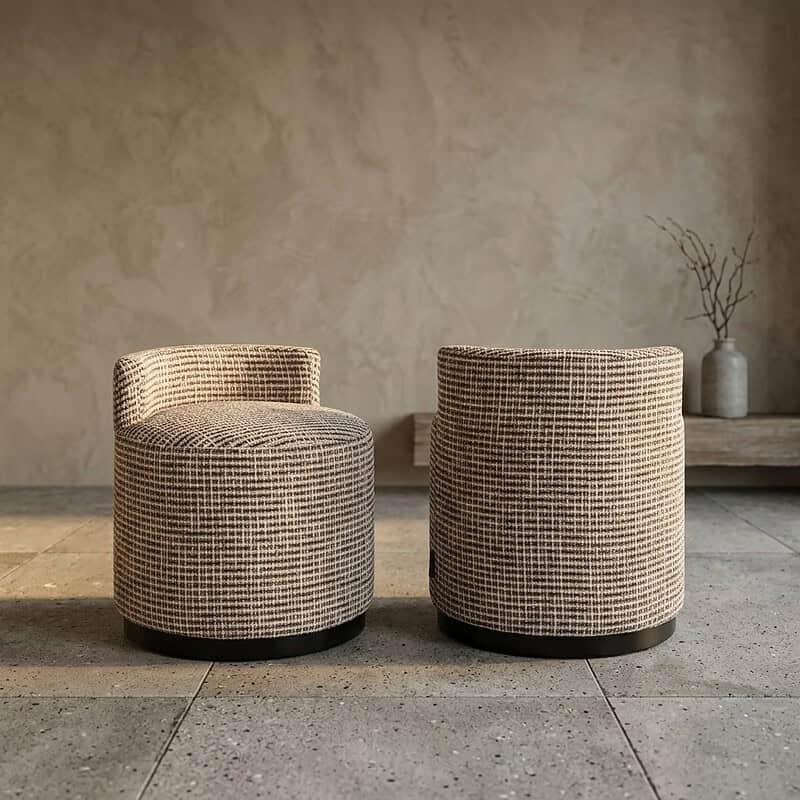 Twee ronde fauteuils met ruitpatroon in een minimalistische woonkamer, perfect voor een stijlvolle en comfortabele zithoek.