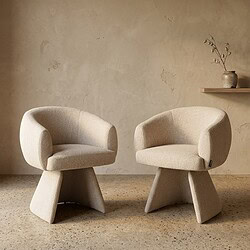 Twee moderne beige fauteuils met ronde rugleuning en sculpturale basis, geplaatst in een minimalistische interieursetting voor een stijlvolle en comfortabele zithoek.