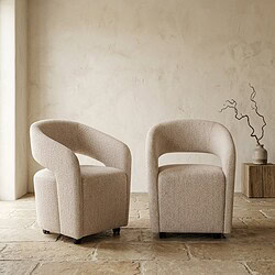 Twee moderne fauteuils in beige stof, geplaatst in een minimalistische woonkamer met een natuurlijke uitstraling en eenvoudige decoratie.