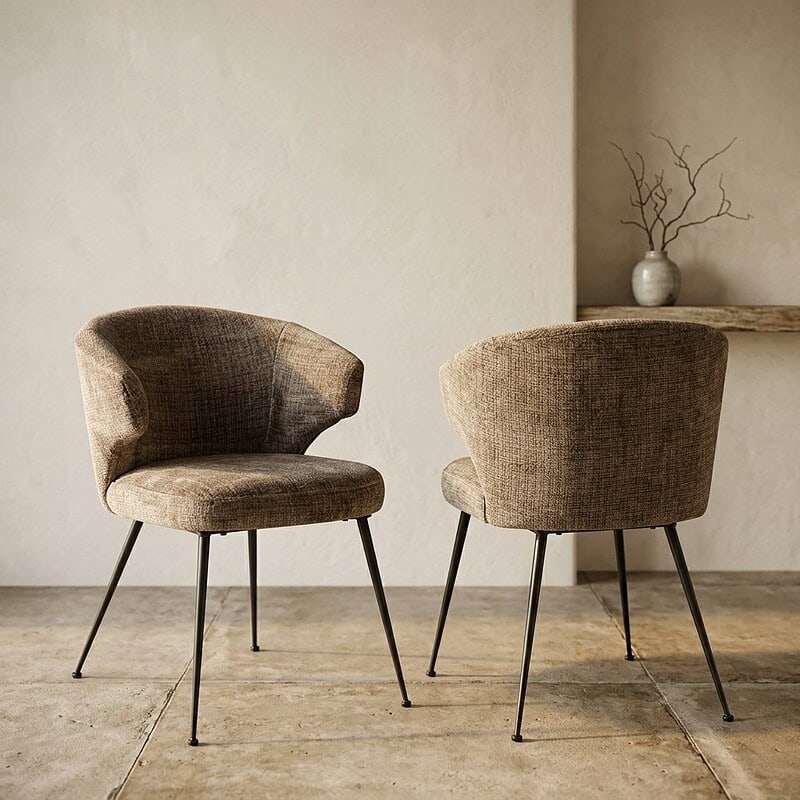 Twee stijlvolle houten eetkamerstoelen met zachte stoffen bekleding en slanke metalen poten, perfect voor een modern interieur.