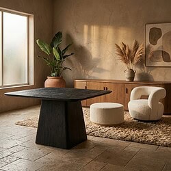 Moderne eettafel en comfortabele fauteuil in een minimalistische woonkamer met natuurlijke decoratie en zachte verlichting.