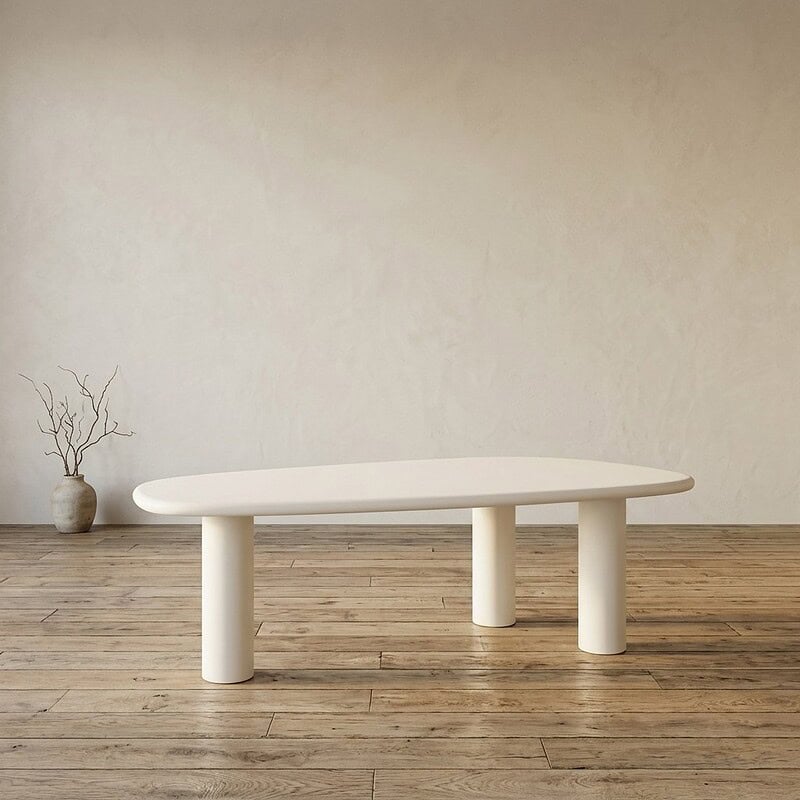 Moderne witte eettafel met uniek ovaal ontwerp en stevige poten, perfect voor een strakke en stijlvolle eetruimte.
