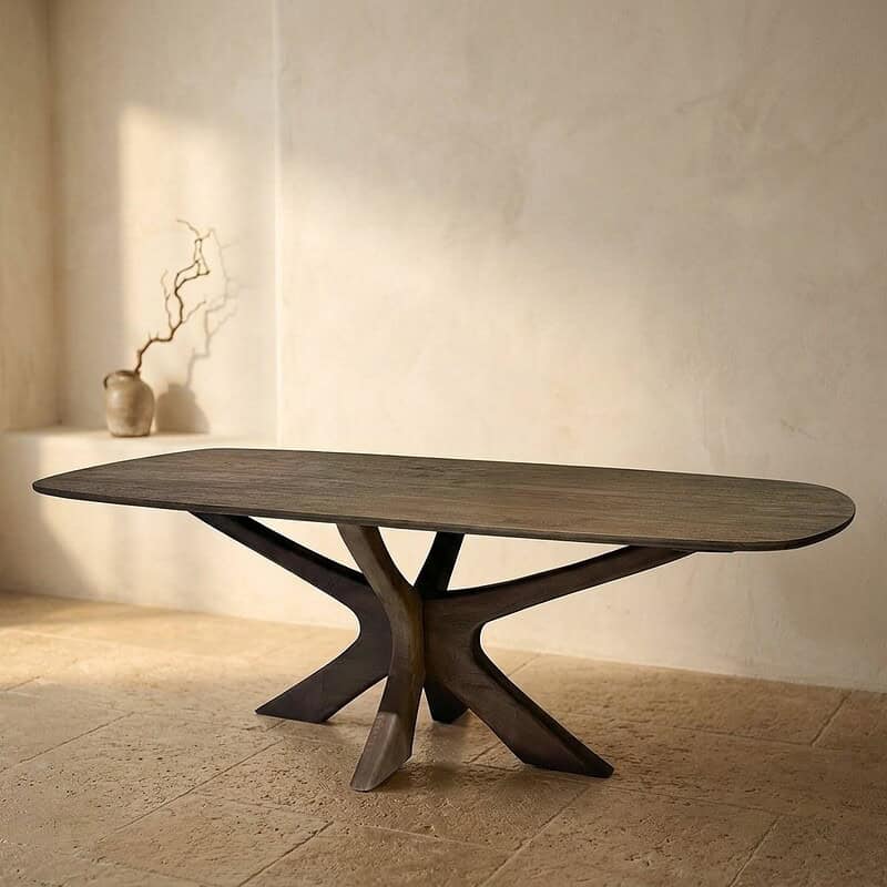 Moderne houten eettafel met een unieke, sculpturale basis en een ruime, ovale tafelblad, perfect voor een stijlvolle eetkamer of woonkamer.