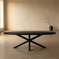 Strakke zwarte houten salontafel met een minimalistisch ontwerp, geplaatst in een lichte, moderne woonkamer met een beige muur en een decoratieve vaas met takken op de achtergrond.