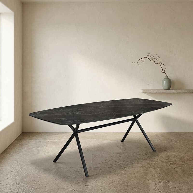 Moderne zwarte eettafel met unieke vorm en strakke lijnen in een minimalistisch interieur, gecombineerd met een decoratieve vaas op een wandplank.