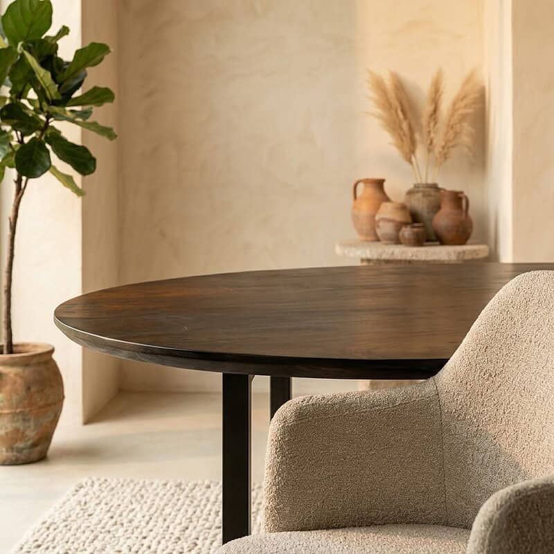 Moderne eettafel met een warme houten afwerking en een comfortabele, gestoffeerde stoel in een stijlvolle interieursetting, perfect voor gezellige diners en bijeenkomsten.