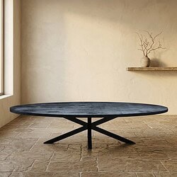 Moderne massief houten eettafel met zwart onderstel in minimalistische woonkamer, natuurlijke lichtinval, rustieke vloer, decoratieve takken in vaas op muurplank.