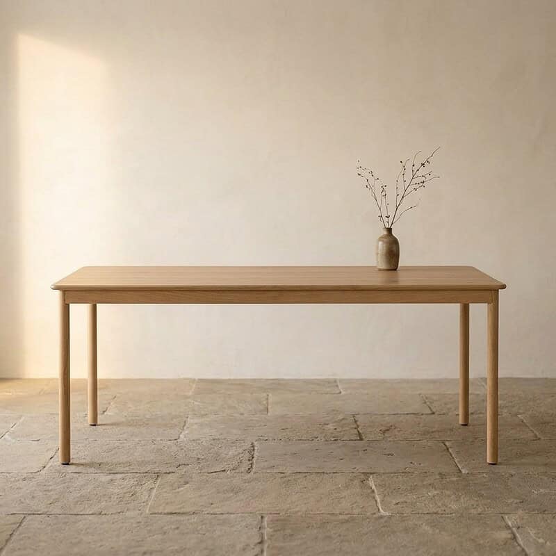 Strakke eettafel van massief hout met minimalistische vaas en takken, perfect voor een moderne en natuurlijke interieurstijl.