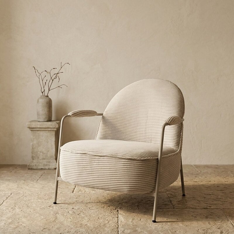 Elegante houten fauteuil met metalen frame en zachte bekleding, perfect voor modern interieur en comfortabele zithoek.