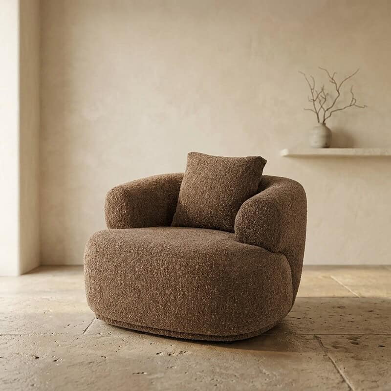 Ein luxuriöser Stoffsessel mit runden Formen und bequemen Kissen – perfekt für eine gemütliche Sitzecke zu Hause. Hergestellt aus hochwertigen Materialien für eine lange Lebensdauer.