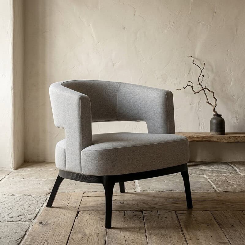 Moderne houten en stoffen fauteuil in minimalistisch interieur met natuurlijke kleuren en eenvoudige decoratie. Perfect voor een stijlvolle en comfortabele zithoek.