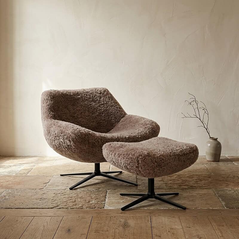 Comfortabele zachte fauteuil met voetenbank in een modern interieur, bekleed met fluffy stof, perfect voor een gezellige zithoek of lounge.