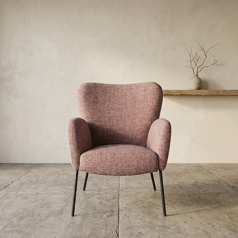 Zachte stoffen fauteuil in roze met slanke zwarte poten, ideaal voor een modern en comfortabel zitplekje in huis.
