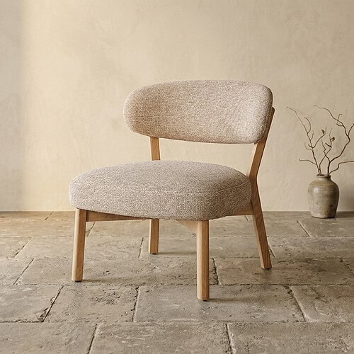 Moderne houten fauteuil met zachte beige bekleding, perfect voor een stijlvolle en comfortabele zithoek in huis.