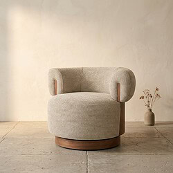 Comfortabele ronde fauteuil met zachte bekleding en houten accenten, perfect voor een stijlvolle en gezellige woonkamer.