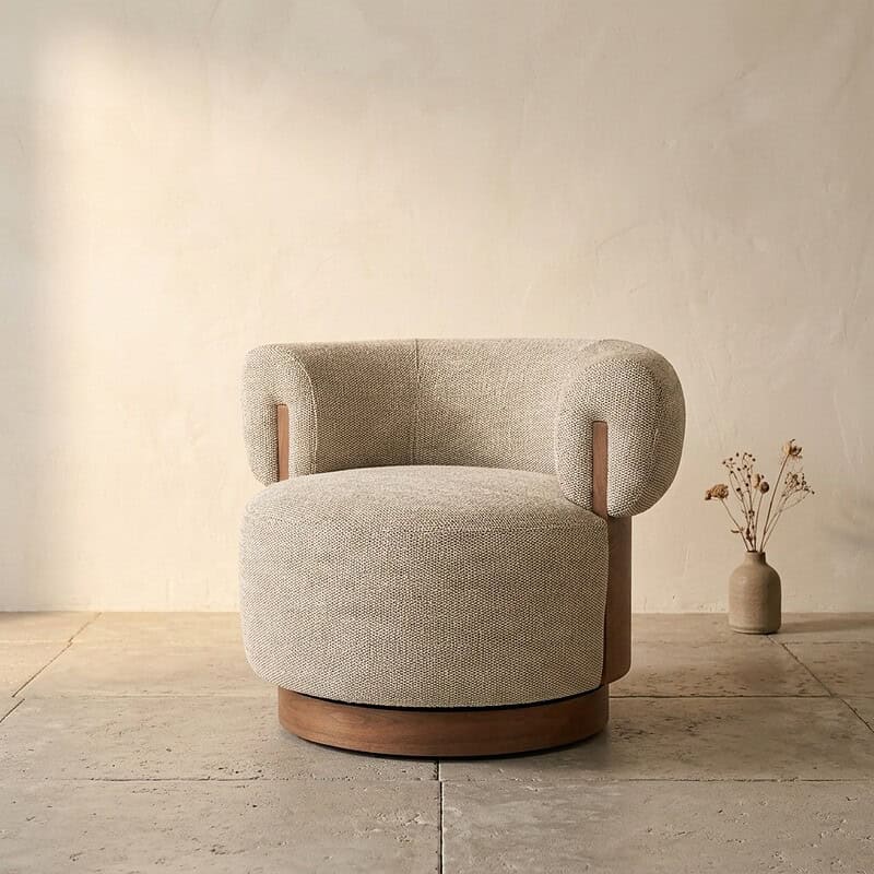 Comfortabele ronde fauteuil met zachte bekleding en houten accenten, perfect voor een stijlvolle en gezellige woonkamer.