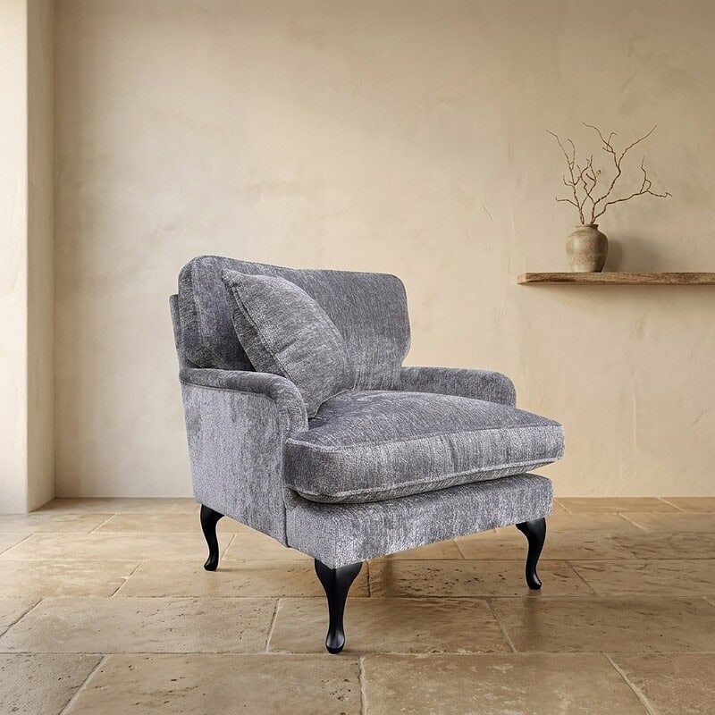 Luxe grijze stoffen fauteuil van Mokana meubelen met klassieke houten poten, perfect voor een stijlvolle woonkamer of zithoek.