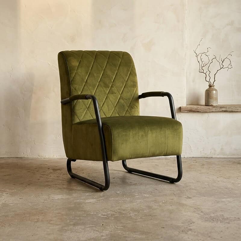 Vintage groen fluwelen fauteuil met houten armleuningen en zwart metalen frame, perfect voor een stijlvolle en comfortabele zithoek.