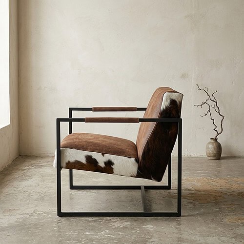 Luxe fauteuil met houten armleuningen, leren zitting en metalen frame, perfect voor modern interieur.