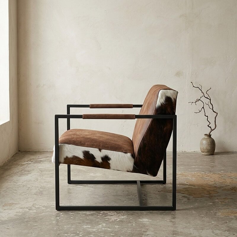 Luxe fauteuil met houten armleuningen, leren zitting en metalen frame, perfect voor modern interieur.