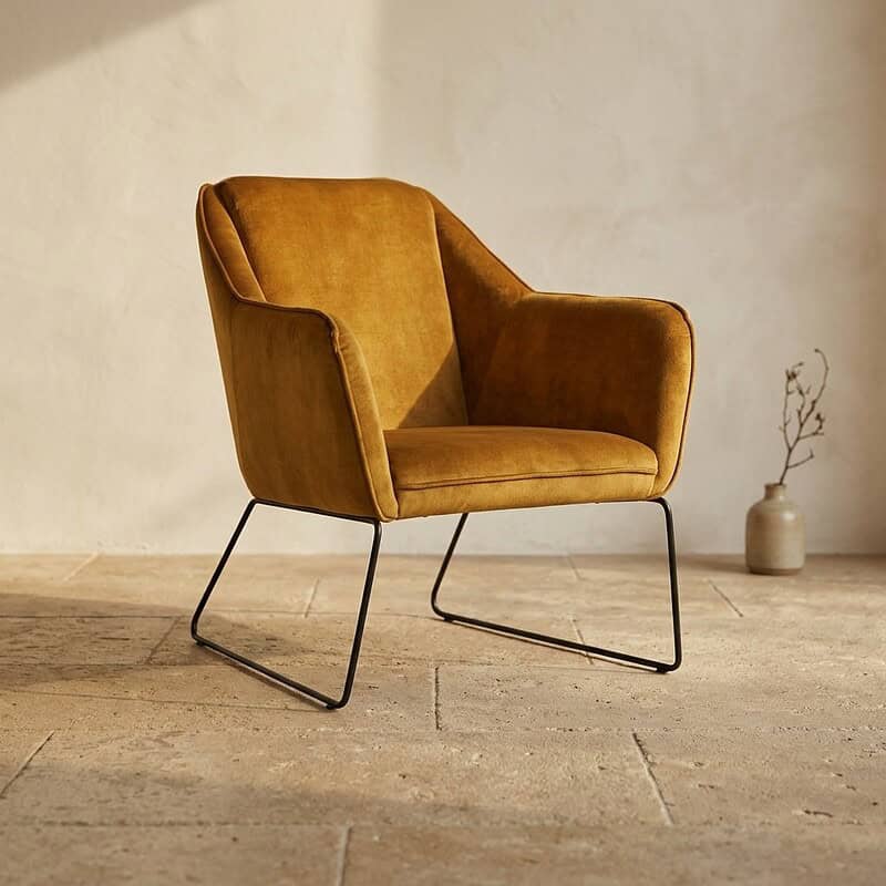 Luxe gouden fauteuil met metalen onderstel, perfect voor moderne interieurdecoratie en comfortabele zithoek.