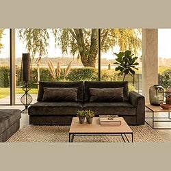 Luxe zwarte fluwelen bank in een moderne woonkamer met grote ramen die uitzicht bieden op een natuurlijke omgeving, perfect voor stijlvolle en comfortabele woonruimtes.