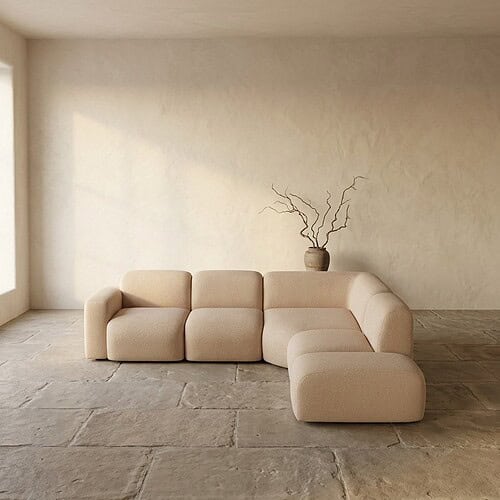 Moderne beige loungebank in een rustige, minimalistische woonkamer met natuurlijke lichtinval en een decoratieve vaas met takken op de achtergrond.