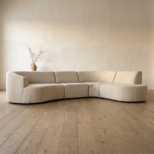 Luxe beige hoekbank in een minimalistische woonkamer, perfect voor moderne interieurs en gezellige zithoeken.