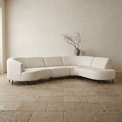Moderne witte hoekbank in een minimalistisch interieur met een vaas en takken op de achtergrond, perfect voor stijlvolle woonruimtes.