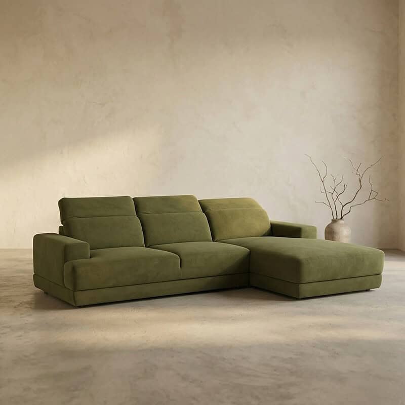 Elegante groene loungebank met chaise longue in een minimalistische woonkamer, perfect voor comfortabel ontspannen en stijlvolle interieurdecoratie.