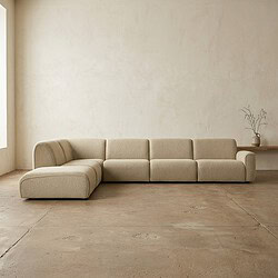 Moderne beige loungebank in een strak, minimalistisch interieur met natuurlijke lichtinval en een eenvoudige decoratie. Perfect voor een stijlvolle en comfortabele zithoek.