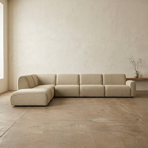 Moderne beige loungebank in een strak, minimalistisch interieur met natuurlijke lichtinval en een eenvoudige decoratie. Perfect voor een stijlvolle en comfortabele zithoek.