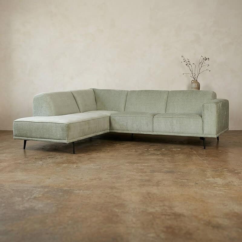 L-vormige bank in lichtgroen stof met houten poten, perfect voor een moderne woonkamer, comfortabel en stijlvol meubelstuk van Mokana Meubelen.