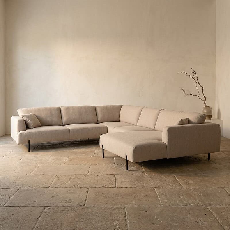 Luxe moderne hoekbank in lichte stof, perfect voor een stijlvolle woonkamer, met strakke lijnen en comfortabele zitplaatsen, ontworpen door Mokana Meubelen.