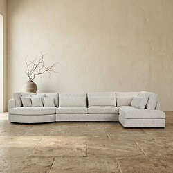 Moderne lichte loungebank in een strakke woonkamer met een decoratieve vaas en takken op de achtergrond, perfect voor een eigentijdse interieurstijl.