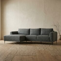 Moderne grijze loungebank in een minimalistische woonkamer met houten vloer en een eenvoudige decoratie, perfect voor een stijlvolle en comfortabele zithoek.
