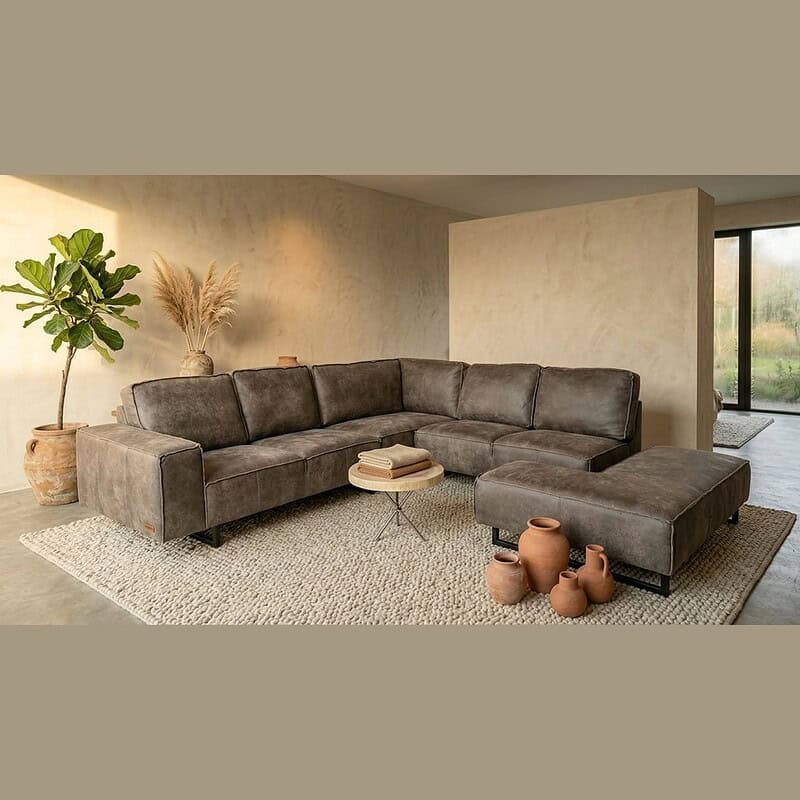 Luxe leren hoekbank in een moderne woonkamer met natuurlijke decoraties en grote ramen, perfect voor stijlvolle en comfortabele zithoeken.